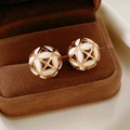 Detailed close-up of vintage flower hollow earrings on a brown velvet jewelry tray - Gold-White