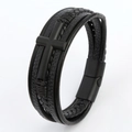 Close-up of layered black leather bracelet featuring a metal cross and magnetic clasp - Black + Matte Black