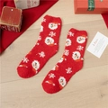 Plush red Christmas socks with Santa and snowflake patterns on a cozy wooden floor - Snowman Head