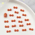 Cute resin orange bow charm for nail art and DIY crafts with yellow center detail - Orange