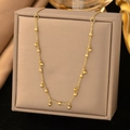 Elegant gold choker necklace with small beads displayed on a premium gray jewelry box - Round Ball Tassel Necklace / Gold