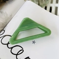 Detail of a large green triangular shark hair claw clip made of glossy resin material - Leaf Green