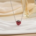 Vue détaillée du pendentif fraise rouge avec chaîne argentée sur support ondulé - Style de Simulation Rouge (XL0546)