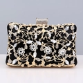 Macro detail of black dinner clutch with golden floral hollow patterns and inlaid rhinestones - Black