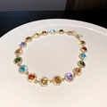 Macro shot of vintage gold bracelet with colorful round gemstones and sparkling zircons - Multicolor Rhinestone Necklace