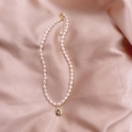 Elegant freshwater pearl necklace with a gold star-engraved teardrop pendant on pink satin - Water Drop