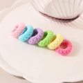 Set di sei elastici per capelli colorati in peluche su un piatto di pizzo decorativo - Multicolore