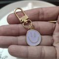 Purple enamel smiley face keychain with golden lobster clasp held by hand - Large Single Purple