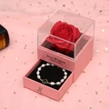 Preserved red rose gift box with a pearl bracelet featuring a green clover charm - Pink Box/Green
