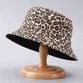Close-up of leopard print bucket hat on a wooden stand showcasing fabric texture - One Size / Khaki Leopard