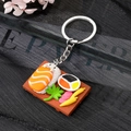 Macro shot of cute salmon sushi keychain on a wooden tray with realistic wasabi and ginger - Plate of Salmon Onigiri