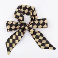 Satin silk scarf featuring a black and gold checkerboard pattern tied in a bow - S75-Black Gold Checkerboard