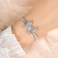 Elegant silver butterfly bracelet with zircon stones worn on wrist against silk background - White