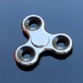 Polished silver tri-spinner fidget toy with black balance weights on blue surface - Electroplated Silver with Iron Weight