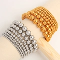 Detail showing gold and silver elastic beaded bracelets in various bead sizes on a display stand - Silver + Gold Set