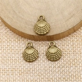 Detailed macro view of antique bronze shell charms on rustic burlap and wood base - Antique Bronze