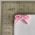 Nœud en perles roses DIY mesurant 3cm par 2cm sur une règle graduée en métal - Nœud de bout de doigt rose n°4