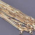 Détail de chaînes serpent carrées de 1,5 mm avec fermoirs mousquetons en acier doré 18 carats - Doré