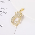 Macro shot of gold-plated G-letter pendant with crown design and shimmering zircons - Letter G