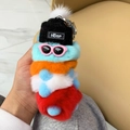 Close-up of a colorful rex rabbit fur caterpillar keychain with a hat and sunglasses - Green Orange White Red