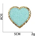 Macrodetail van hartvormige blauwe chenille patch met gouden glitter borduursel en 5cm maat - Nr.7 - Lichtblauw Hart