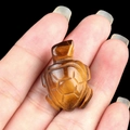 Miniature tiger eye turtle carving held in hand showing small size and stone texture - Tiger's Eye