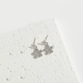 Eleganti orecchini a fiore in argento con strass scintillanti su sfondo di marmo bianco - Fiore di Zircone a Cinque Petali Argento