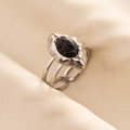 Détail d'une bague rétro argentée avec pierre noire ovale sur un tissu en maille - Argent-Noir