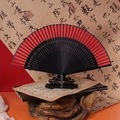 Classic Chinese folding fan in red and black with an elegant black wooden stand - 42 Square Red