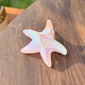Iridescent starfish hair claw clip with colorful laser finish on dark wood background - Starfish Claw Clip / Pink Iridescent