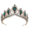 Macro view of golden baroque crown with emerald green stones and diamond accents - KC Gold White & Olive Green Rhinestone