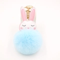 Vista dettagliata del morbido pompon di peluche azzurro e della catena dorata ad anello - Portachiavi d'Oro / Azzurro
