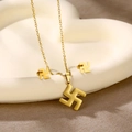 Detailed view of golden heart and geometric angel pendant set on white display tray - Swastika (TZ-456)