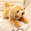 Golden Retriever plush toy in a soft lying position on a cozy knitted blanket - Labrador