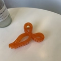 Detailed close-up of an orange ribbon bow hair claw clip with a durable gold spring - Jelly Orange