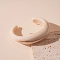 Detail of cream acrylic marble open bangle on a textured stone surface with luxury mood - Marbled White Open Bangle