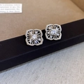 Dettaglio macro di orecchini a fiore in argento con zircone e petali con trama incisa - Stile Zircone Fiore Cavo a Quattro Petali / Argento