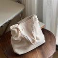 Detailaufnahme der V-förmigen Webstruktur einer beigefarbenen Canvas-Schultertasche - Schulter-Achseltasche / Gebrochenes Weiß