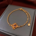 Gros plan d'un bracelet doré à perles avec pierre violette et détail de pendentif coeur - 26# Or-Plaqué or véritable