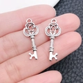 Antique silver retro key-shaped pendant DIY jewelry charm held in hand for scale - Small Key 10x27mm (3112)