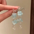 Hand holding light blue floral dangle earrings with silver chains and clear beads - 36# Silver Pin - Silver Blue
