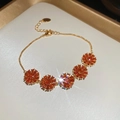 Close-up of 18k gold-plated bracelet featuring orange zircon flowers and lobster clasp - Orange