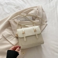Elegant white vintage shoulder bag with gold hardware on beige suit and bed sheets - White