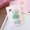 Set dettagliato di tre fermagli per capelli ovali in tessuto verde su card - Set Verde
