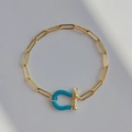 Golden paperclip chain bracelet featuring a vibrant blue horseshoe U-shaped clasp - Blue