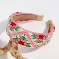 Detail of pink hand-crocheted floral headband displayed on light-colored driftwood - Flat Pink Green