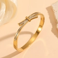 Detail of a thin gold titanium steel bracelet with pavé-set square cubic zirconia stones - Gold Bowknot Style (M713)