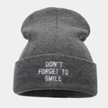 Detailed view of dark grey ribbed beanie featuring white embroidered slogan on the cuff - One Size / Dark Gray