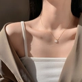 Close-up of minimalist gold square pearl pendant necklace worn by model on collarbone - Square Mother of Shell (XL1344)
