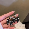 Black polka dot bow earrings with gold floral base and white pearls held by hand - 50# Silver Needle - Black